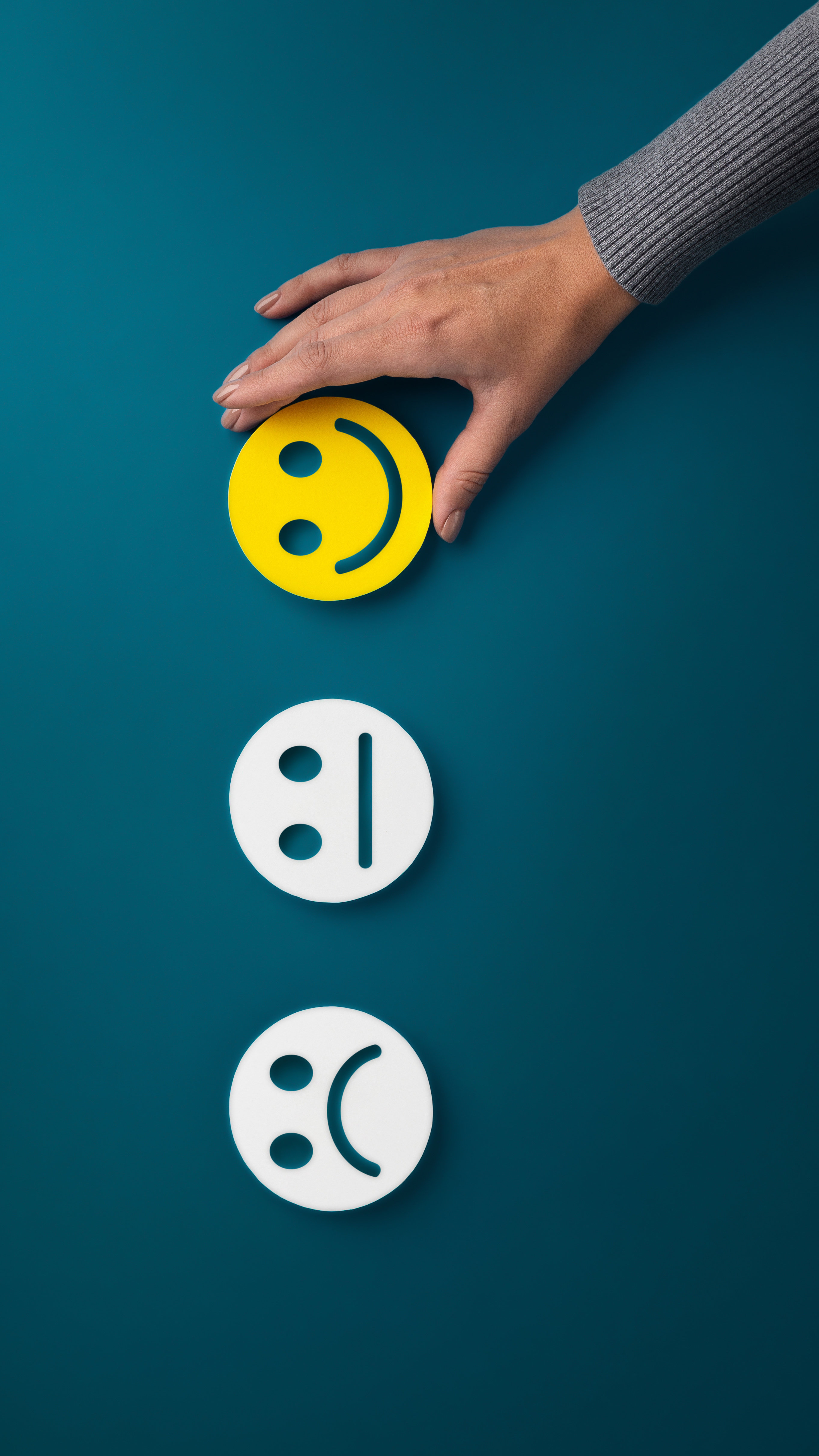 trze emotki, dłoś wskazuje na usmiech